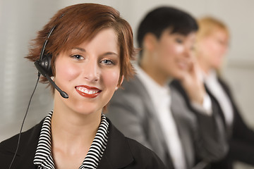 Image showing Pretty Red Haired Businesswoman with Headset and Colleagues