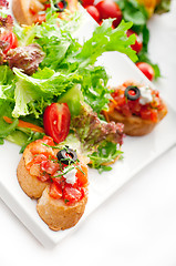 Image showing original Italian fresh bruschetta served with fresh salad and ve