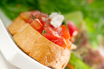 Image showing original Italian fresh bruschetta served with fresh salad and ve