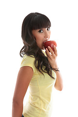 Image showing Girl biting into a red apple