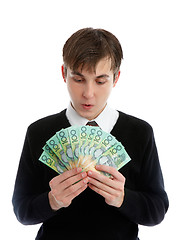 Image showing Student or young worker looking down at handful of cash