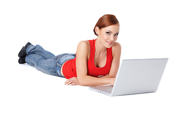 Image showing Cute female lying down and using a laptop