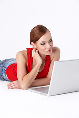 Image showing Cute female lying down and using a laptop