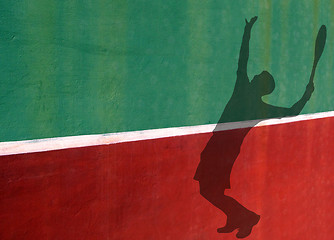 Image showing Tennis Player Serving Silhouette Against Practice Wall