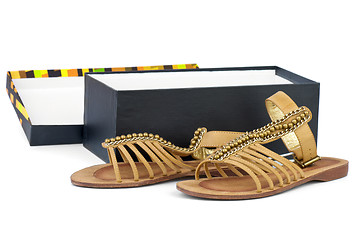 Image showing Pair of brown leather female sandals near opened box