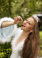 Image showing Maiden eats cherries