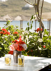 Image showing two beer in mugs view of Ios Cyclades in background