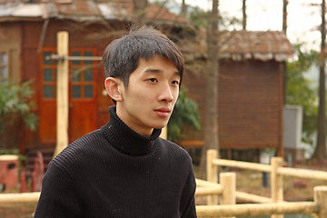 Image showing Asian man stand against a old house 