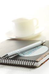 Image showing Pen on a white paper with cup of coffee