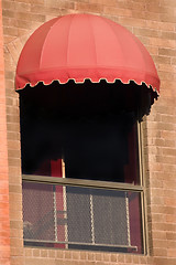 Image showing Brick Wall and A Window with Red Awning