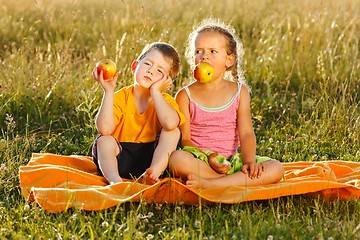 Image showing Little girl and boy eating apple