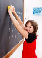 Image showing Elementary school student erasing chalkboard