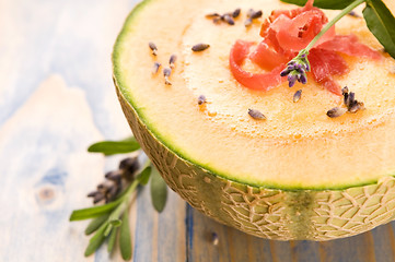 Image showing fresh melon soup with parma ham and lavender flower