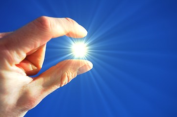 Image showing hand fingers sky and sun