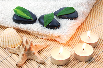 Image showing foldet white bath towel and zen stones