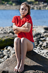 Image showing girl badly frozen sitting on a rock