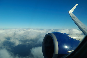 Image showing Wing of Boeing 737 jet plane flying over clouds