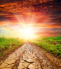 Image showing sunset over cracked rural road