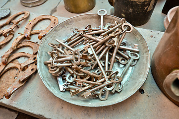 Image showing a lot of old brass key on an old plate