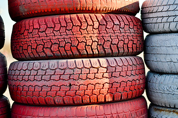 Image showing close up of racetrack fence of  red and white old tires