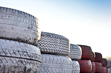 Image showing close up of racetrack fence of  red and white old tires