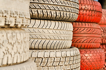 Image showing close up of racetrack fence of white and red of old tires