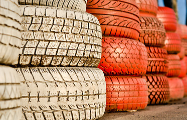Image showing close up of racetrack fence of white and red of old tires