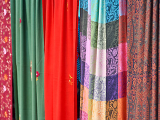 Image showing colorful patterned fabrics hanging in a row