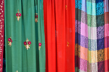 Image showing colorful patterned fabrics hanging in a row