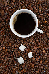 Image showing Coffee cup with sugar on roasted beans