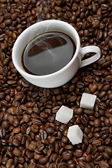 Image showing Coffee cup with sugar on roasted beans