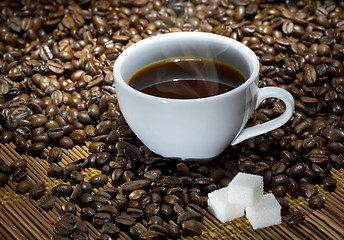 Image showing Coffee cup with sugar on roasted beans
