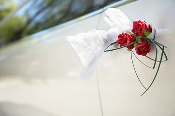 Image showing Door of white wedding car with flower and white bow