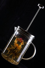 Image showing French-press with tea in black background