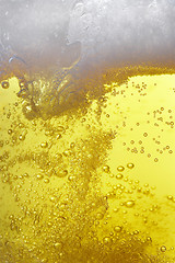 Image showing lots of bubbles floating in a beer with froth on top