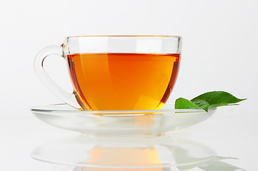 Image showing Cup with tea and green leaf