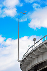 Image showing lamppost at the overpass on background of blue sky with clouds