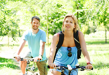 Image showing Young happy couple riding a bicycle