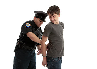 Image showing Policeman handcuffing teenager