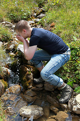 Image showing Young man taking a refreshment in the mountains