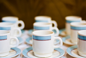 Image showing nine white porcelain tea cups and saucers and napkins