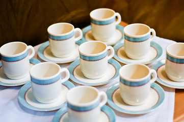 Image showing nine white porcelain tea cups and saucers and napkins