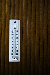 Image showing room thermometer on a wooden wall close up