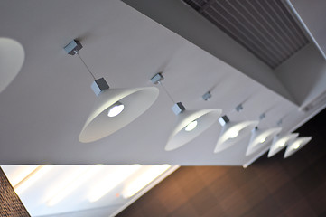 Image showing several modern chandeliers on the ceiling in the bar