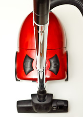 Image showing The red vacuum cleaner with a black hose on a white background
