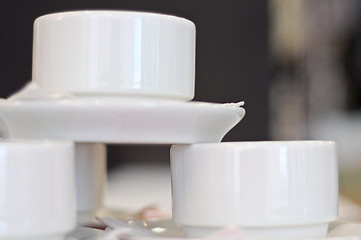 Image showing three white porcelain tea cups and saucers and napkins close up