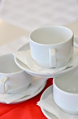 Image showing three white porcelain tea cups and saucers and napkins