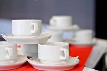 Image showing three white porcelain tea cups and saucers and napkins close up