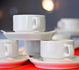 Image showing three white porcelain tea cups and saucers and napkins close up