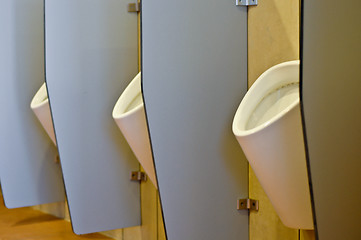 Image showing Urinals behind partitions in a toilet in office building